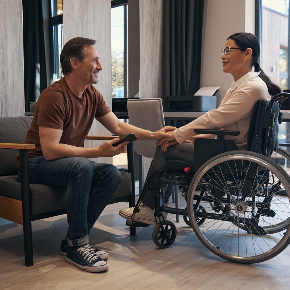 cheerful-man-enjoying-communication-with-woman-with-disability